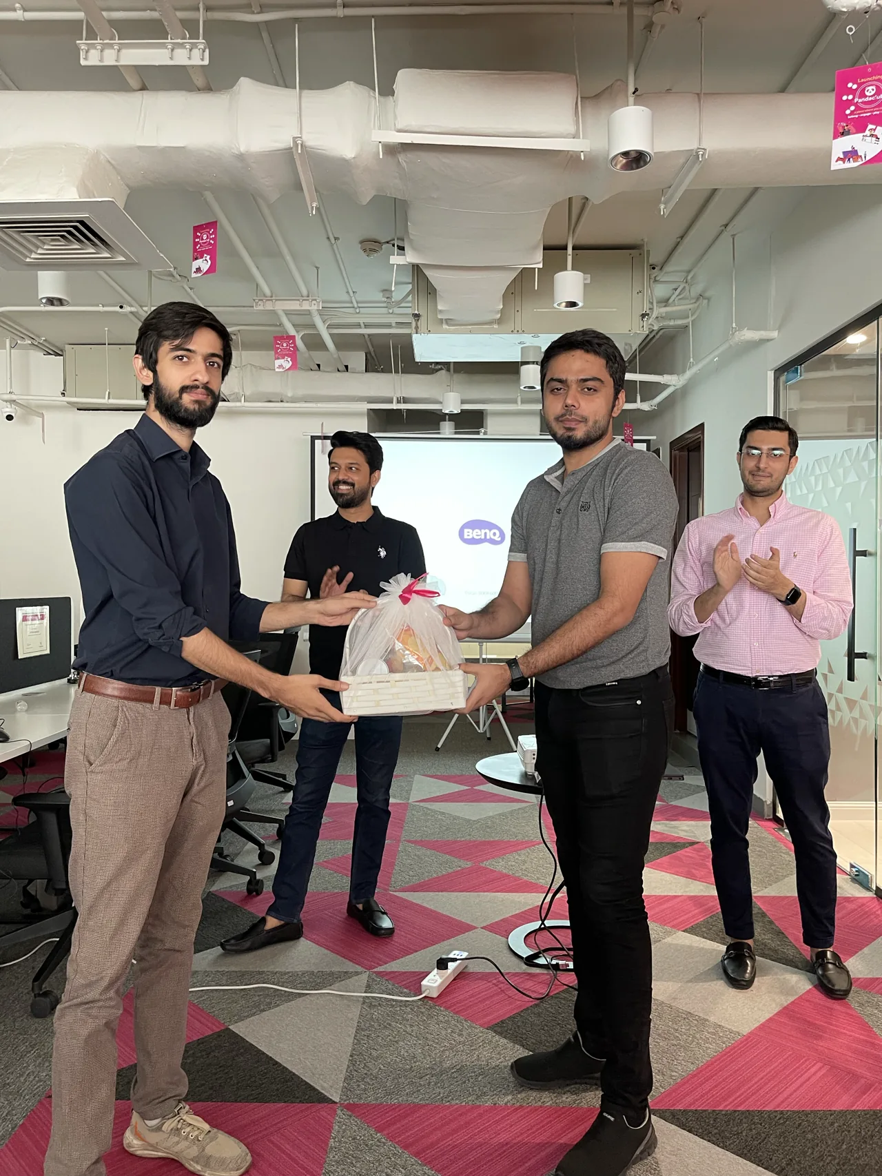 Taimour Tariq presenting a gift basket to a teammate at Foodpanda