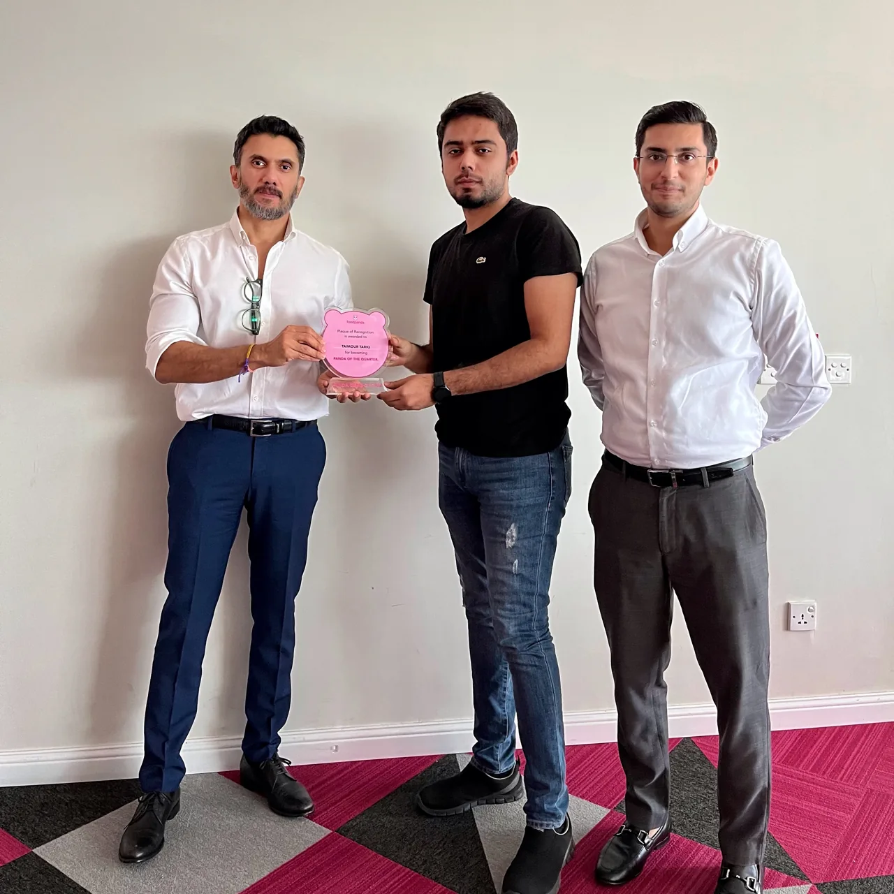 Taimour Tariq receiving Foodpanda’s Panda of the Quarter plaque alongside manager Usman Saleem and a marketing director