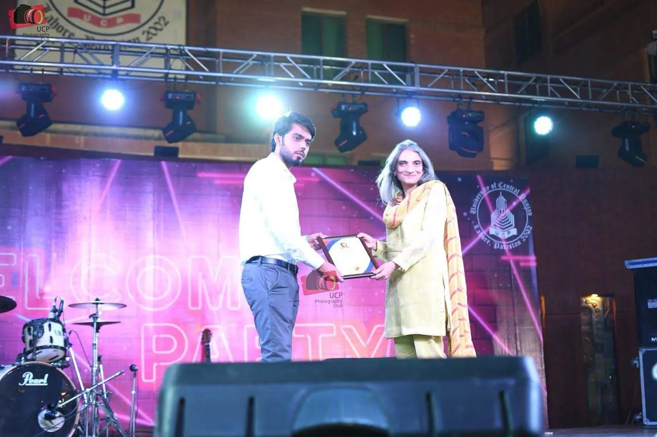 Taimour Tariq receiving an Excellence Award certificate on stage at the University of Central Punjab